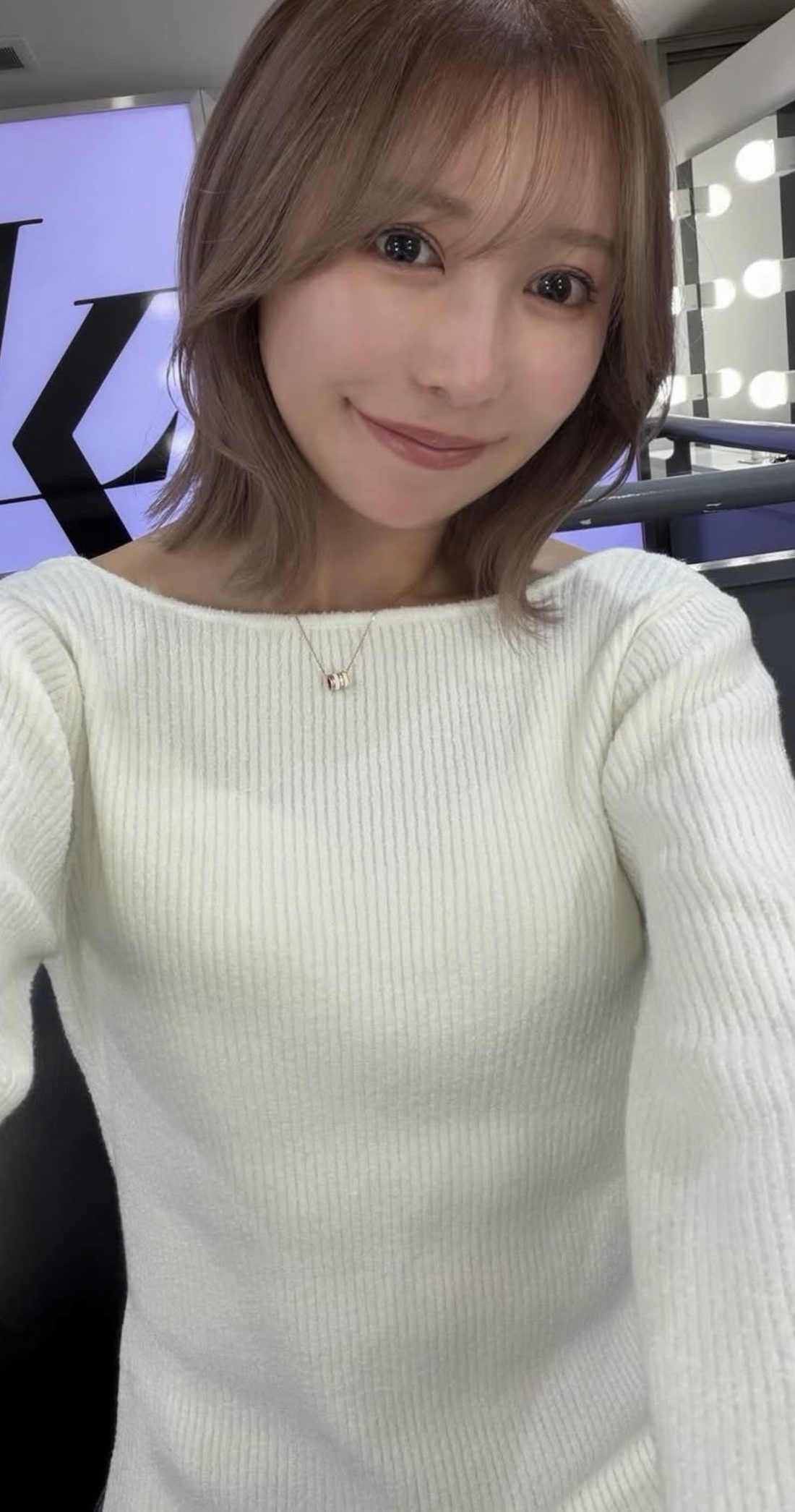 白いニットを着た笑顔の自撮り